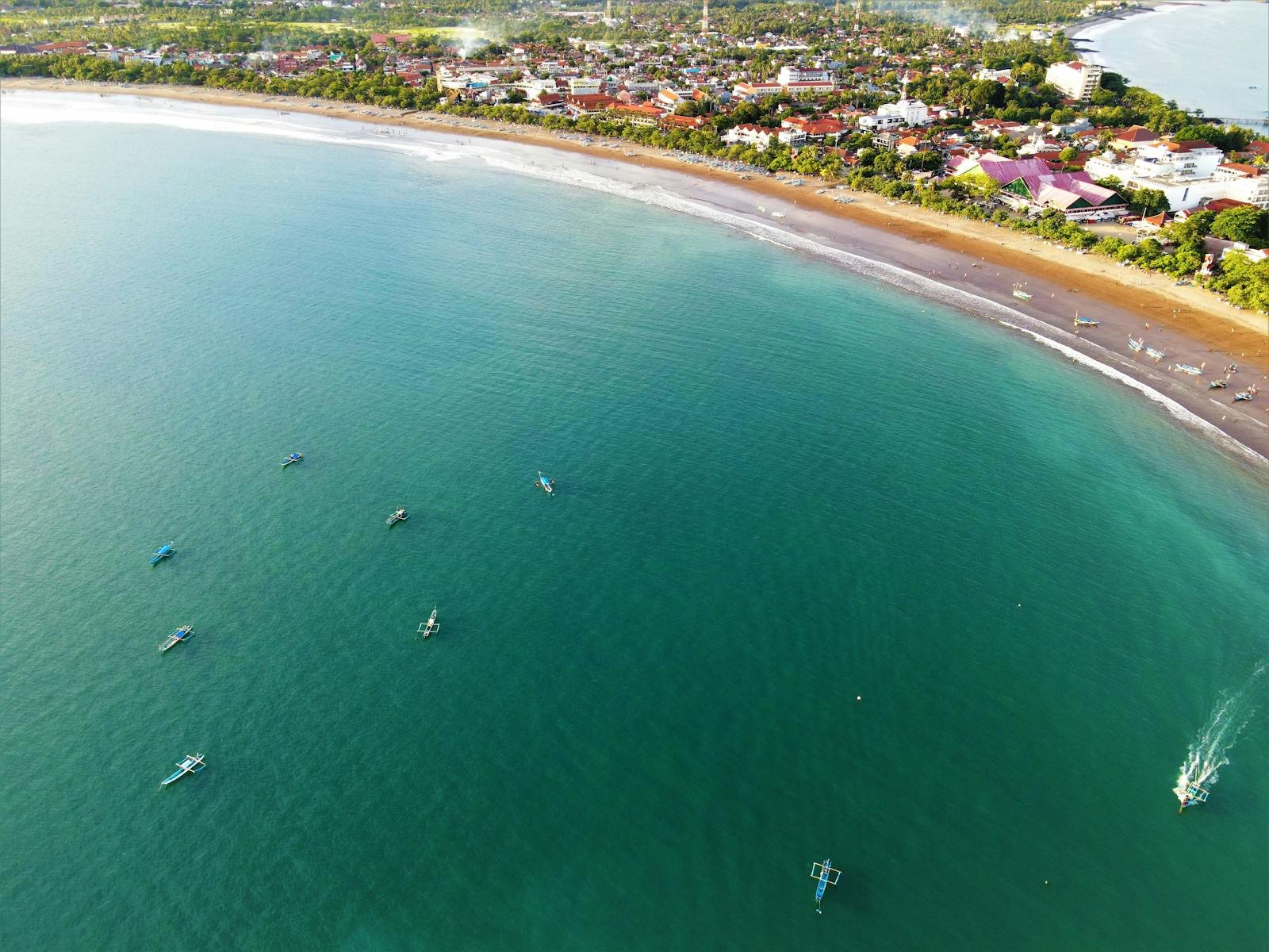 Drone shot capturing the coastline and boats along Pangandaran Beach in Indonesia.