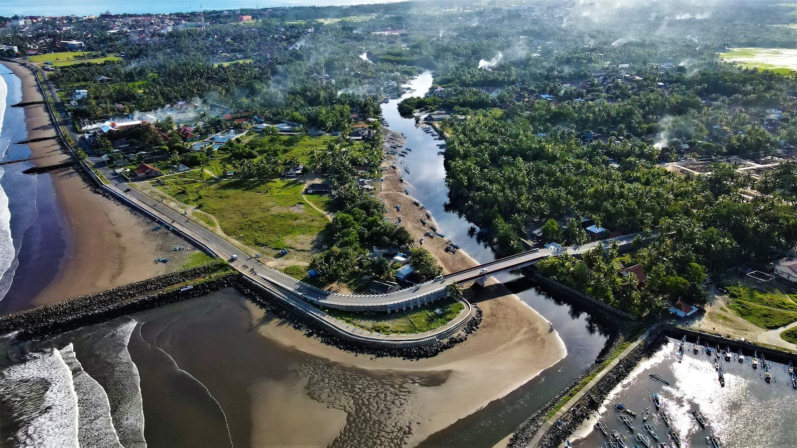 Stunning aerial view of Pangandaran coastline with lush greenery and winding estuary in Indonesia.
